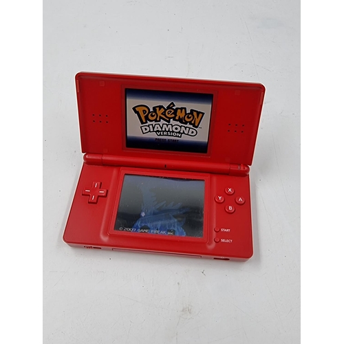 1506 - A red Nintendo DS lite hand held console with Pokémon Diamond version game