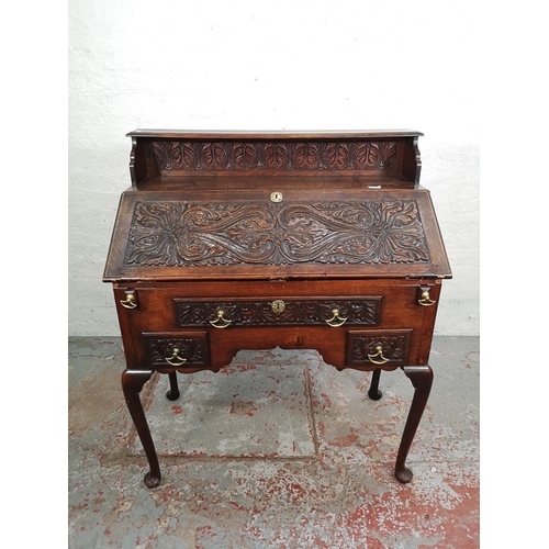 1002 - A late 19th/early 20th century Macclesfield School of Carving oak writing desk with fall front, thre... 