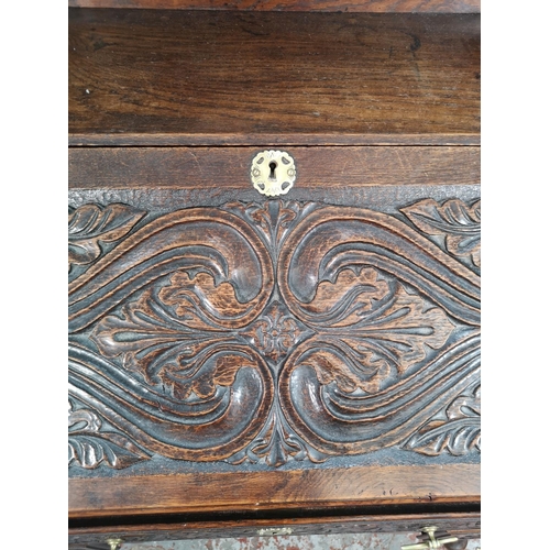 1002 - A late 19th/early 20th century Macclesfield School of Carving oak writing desk with fall front, thre... 