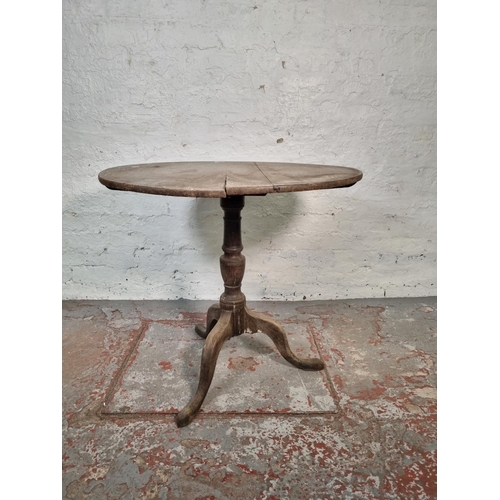 1054 - A 19th century oak tilt top tripod table - approx. 72cm high x 78cm diameter