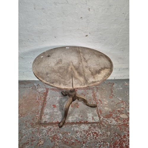 1054 - A 19th century oak tilt top tripod table - approx. 72cm high x 78cm diameter