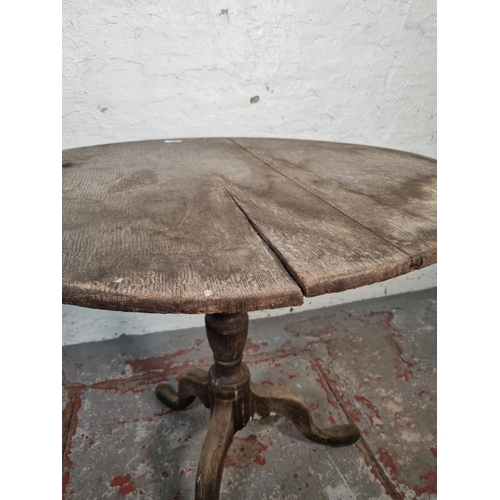 1054 - A 19th century oak tilt top tripod table - approx. 72cm high x 78cm diameter