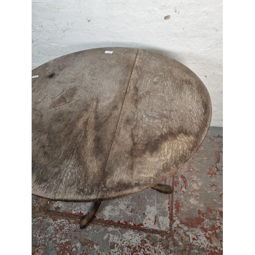 1054 - A 19th century oak tilt top tripod table - approx. 72cm high x 78cm diameter