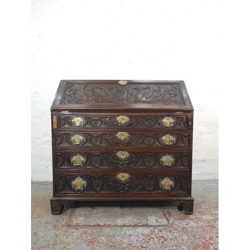 1001 - A Victorian Gothic Revival carved oak bureau with four drawers, fall front and fitted interior  - ap... 