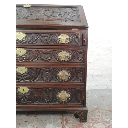 1001 - A Victorian Gothic Revival carved oak bureau with four drawers, fall front and fitted interior  - ap... 