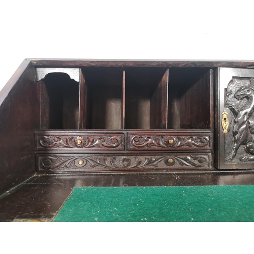 1001 - A Victorian Gothic Revival carved oak bureau with four drawers, fall front and fitted interior  - ap... 