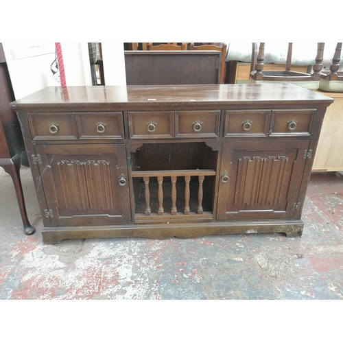 1005 - A late 20th century oak linenfold sideboard with three upper drawers and two lower cupboard doors - ... 