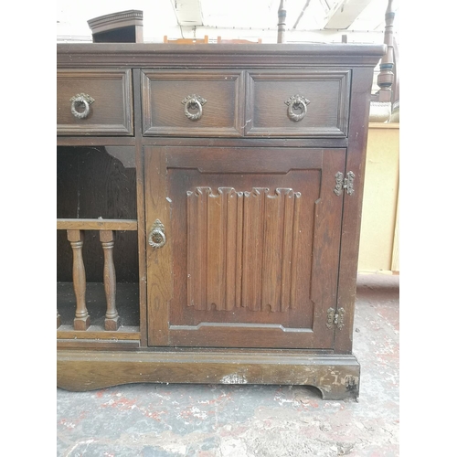 1005 - A late 20th century oak linenfold sideboard with three upper drawers and two lower cupboard doors - ... 