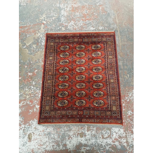 1012 - A red Bokhara rug - approx. 170cm long x 133cm wide