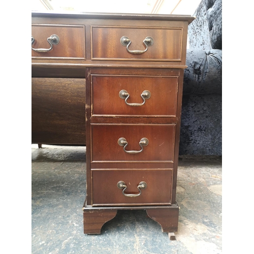 1022 - A 19th century style mahogany pedestal desk with green leather insert and nine drawers - approx. 77c... 