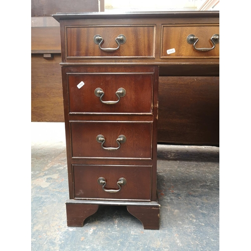 1022 - A 19th century style mahogany pedestal desk with green leather insert and nine drawers - approx. 77c... 