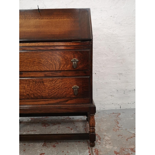 1028 - A 1930s oak bureau with two drawers, fall front and fitted interior - approx. 99cm high x 72cm wide ... 