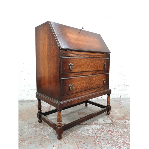 1028 - A 1930s oak bureau with two drawers, fall front and fitted interior - approx. 99cm high x 72cm wide ... 