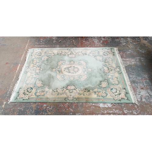 1032 - A large Chinese green rug - approx. 389cm x 278cm