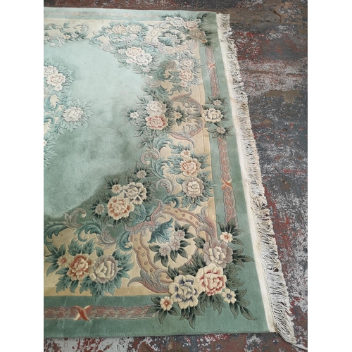 1032 - A large Chinese green rug - approx. 389cm x 278cm