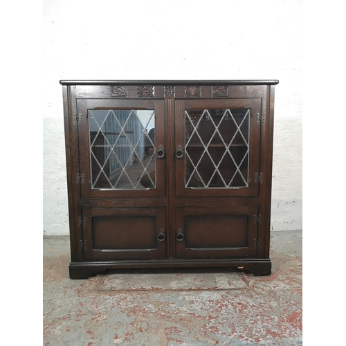 1037 - An oak bookcase with two leaded glass doors and two lower cupboard doors - approx. 99cm high x 103.5... 