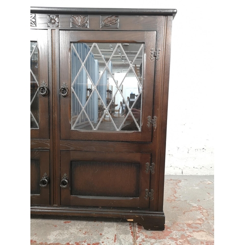 1037 - An oak bookcase with two leaded glass doors and two lower cupboard doors - approx. 99cm high x 103.5... 