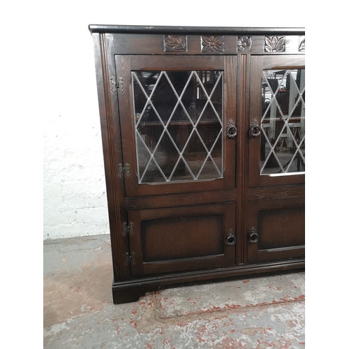 1037 - An oak bookcase with two leaded glass doors and two lower cupboard doors - approx. 99cm high x 103.5... 