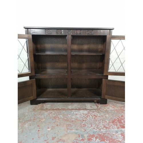 1037 - An oak bookcase with two leaded glass doors and two lower cupboard doors - approx. 99cm high x 103.5... 