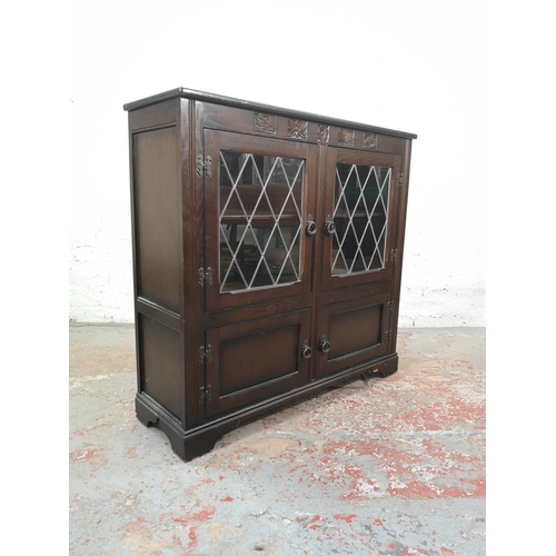 1037 - An oak bookcase with two leaded glass doors and two lower cupboard doors - approx. 99cm high x 103.5... 