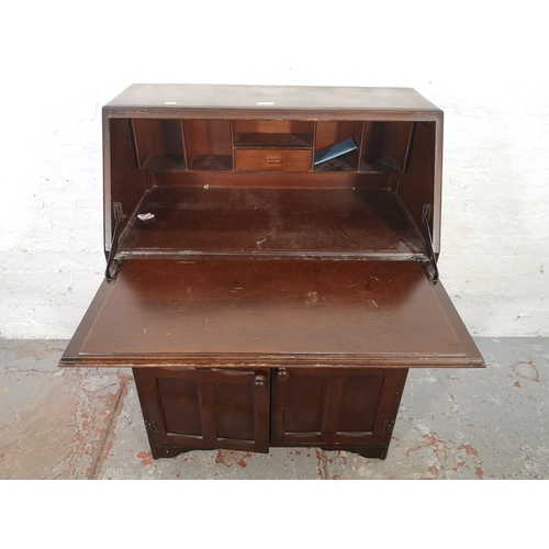 1042 - A mid 20th century oak bureau with two lower cupboard doors, single drawer and fall front - approx. ... 