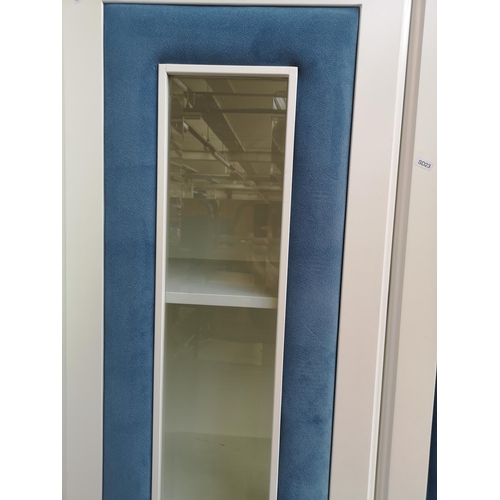 1060 - A contemporary white painted and blue fabric bedroom display cabinet with two bevelled glass doors a... 