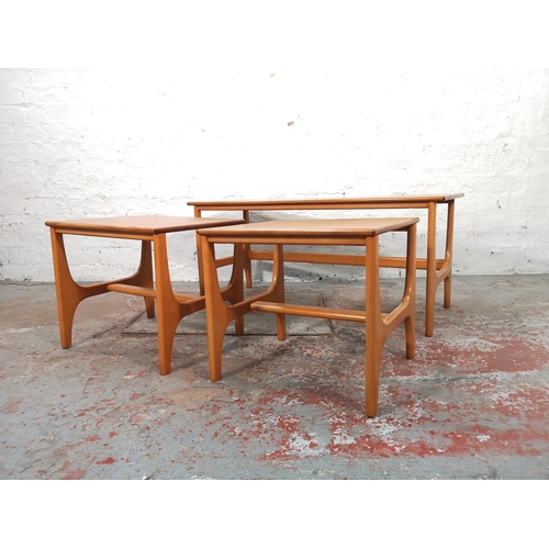 1071 - A teak and beech nest of three tables - largest approx. 44cm high x 40cm wide x 100cm long