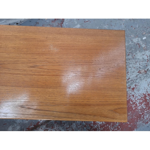 1071 - A teak and beech nest of three tables - largest approx. 44cm high x 40cm wide x 100cm long