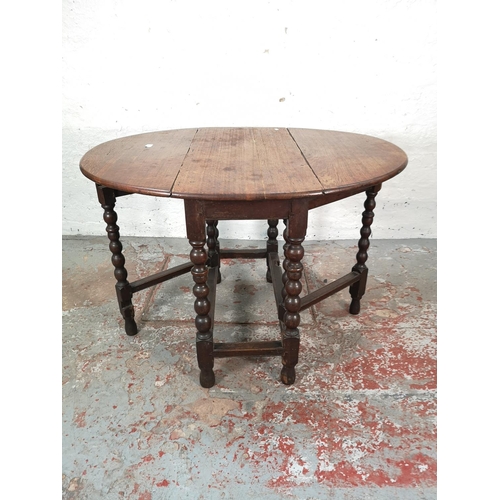 1081 - An 18th century oak drop leaf gate leg oval dining table with barley twist supports - approx. 72cm h... 