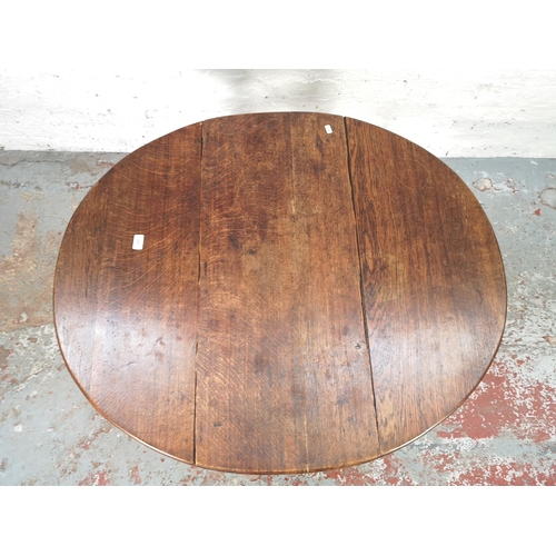 1081 - An 18th century oak drop leaf gate leg oval dining table with barley twist supports - approx. 72cm h... 