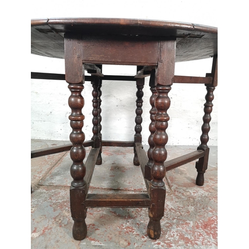 1081 - An 18th century oak drop leaf gate leg oval dining table with barley twist supports - approx. 72cm h... 