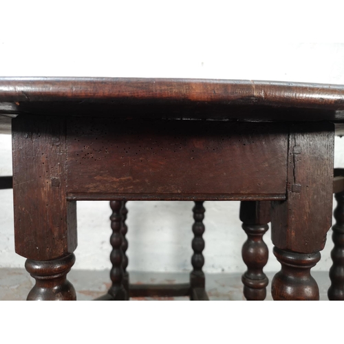 1081 - An 18th century oak drop leaf gate leg oval dining table with barley twist supports - approx. 72cm h... 