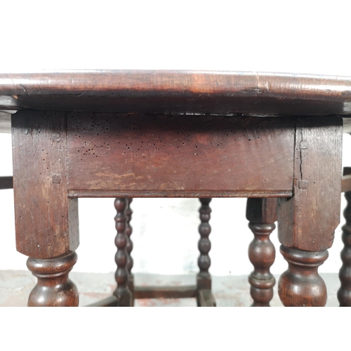 1081 - An 18th century oak drop leaf gate leg oval dining table with barley twist supports - approx. 72cm h... 