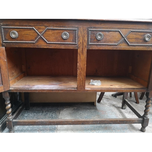 1082 - A 1920s oak mirror back sideboard with two drawers, two cupboard doors, oval bevel edged mirror and ... 