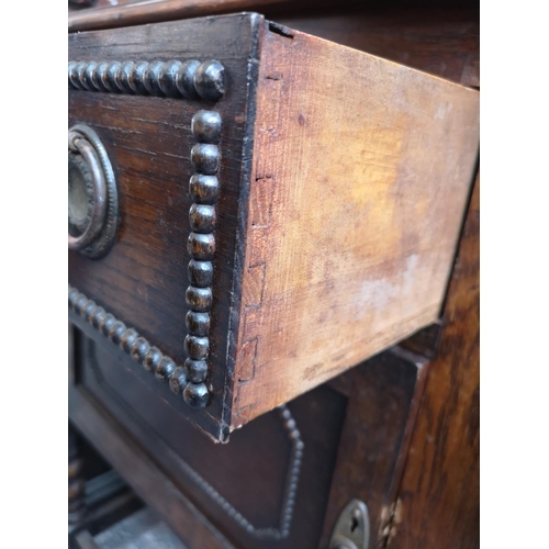 1082 - A 1920s oak mirror back sideboard with two drawers, two cupboard doors, oval bevel edged mirror and ... 