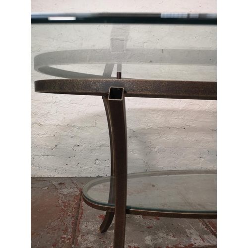 1084 - A contemporary wrought iron two tier oval dining table with bevelled glass top - approx. 76cm high x... 