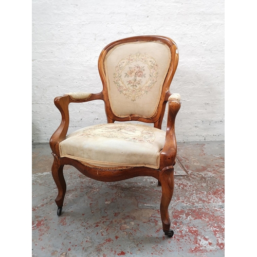 1101 - A Victorian walnut armchair with floral tapestry upholstery and casters - approx. 98cm high x 61cm w... 