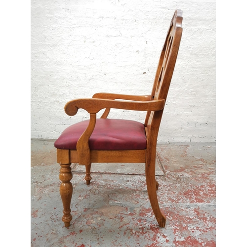 1102 - A set of four late 20th century oak and red vinyl dining chairs