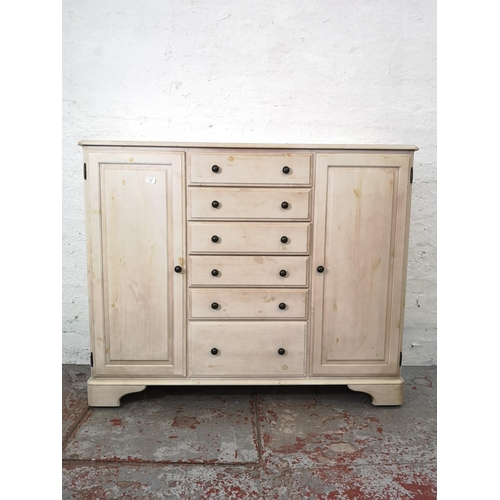 1109 - A Ducal white painted pine sideboard with six central drawers and two outer cupboard doors - approx.... 