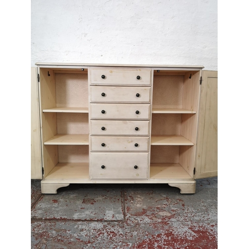 1109 - A Ducal white painted pine sideboard with six central drawers and two outer cupboard doors - approx.... 