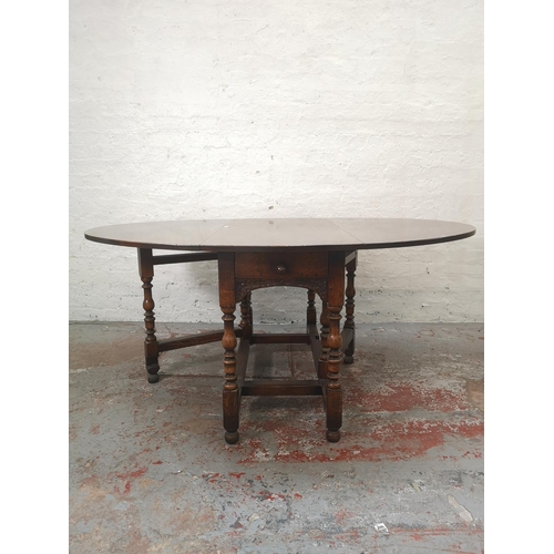 1137 - An 18th century style solid English oak drop leaf gate leg dining table with single drawer - approx.... 