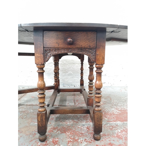 1137 - An 18th century style solid English oak drop leaf gate leg dining table with single drawer - approx.... 