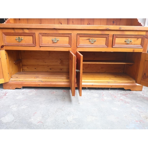 1140 - A 19th century style solid pine Welsh dresser with upper three tier plate rack, four drawers and fou... 