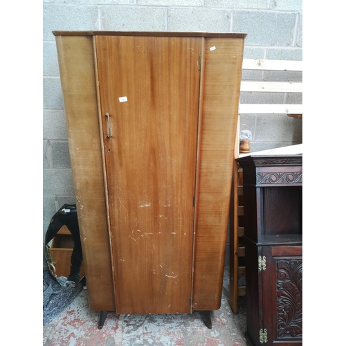 1144 - A mid 20th century Homeworthy walnut single door wardrobe with black painted splayed supports - appr... 