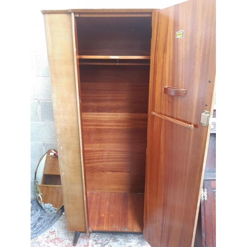 1144 - A mid 20th century Homeworthy walnut single door wardrobe with black painted splayed supports - appr... 