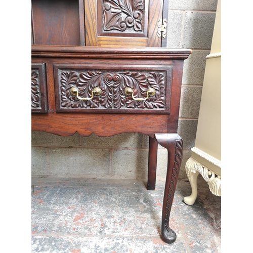 1147 - A late 19th/early 20th century carved oak dresser with two cupboard doors, upper plate rack, three d... 