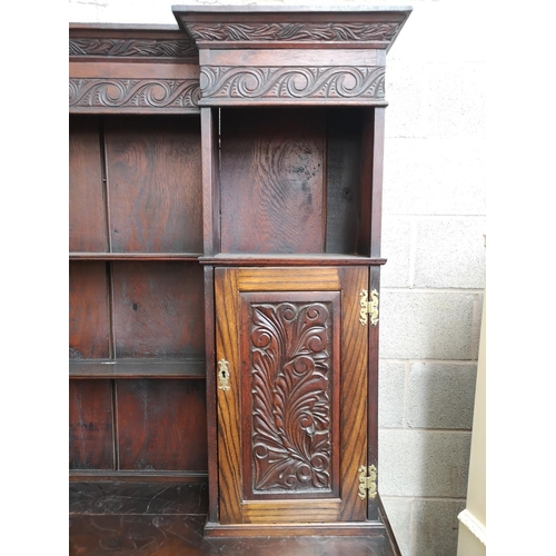 1147 - A late 19th/early 20th century carved oak dresser with two cupboard doors, upper plate rack, three d... 