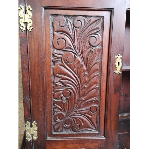 1147 - A late 19th/early 20th century carved oak dresser with two cupboard doors, upper plate rack, three d... 