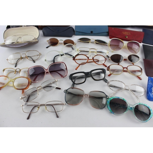 715 - A collection of assorted pairs of vintage sunglasses and spectacles to include Polaroid, 70's etc.