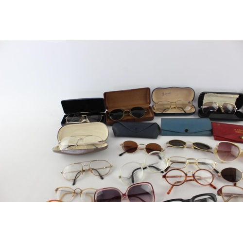 715 - A collection of assorted pairs of vintage sunglasses and spectacles to include Polaroid, 70's etc.